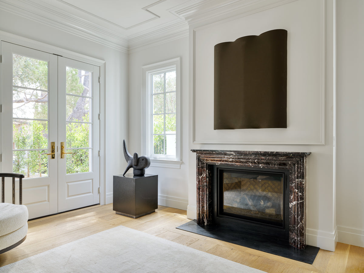 Rouge marble mantel with a sculpture on a plinth alongside, Martin & Brockett Beverly Hills
