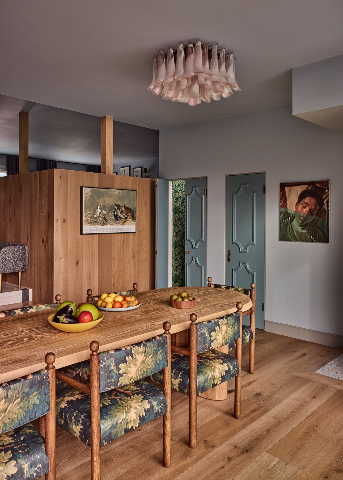 Oval oak table with tapestry-upholstered chairs below a pink glass light, Martin & Brockett Canyon