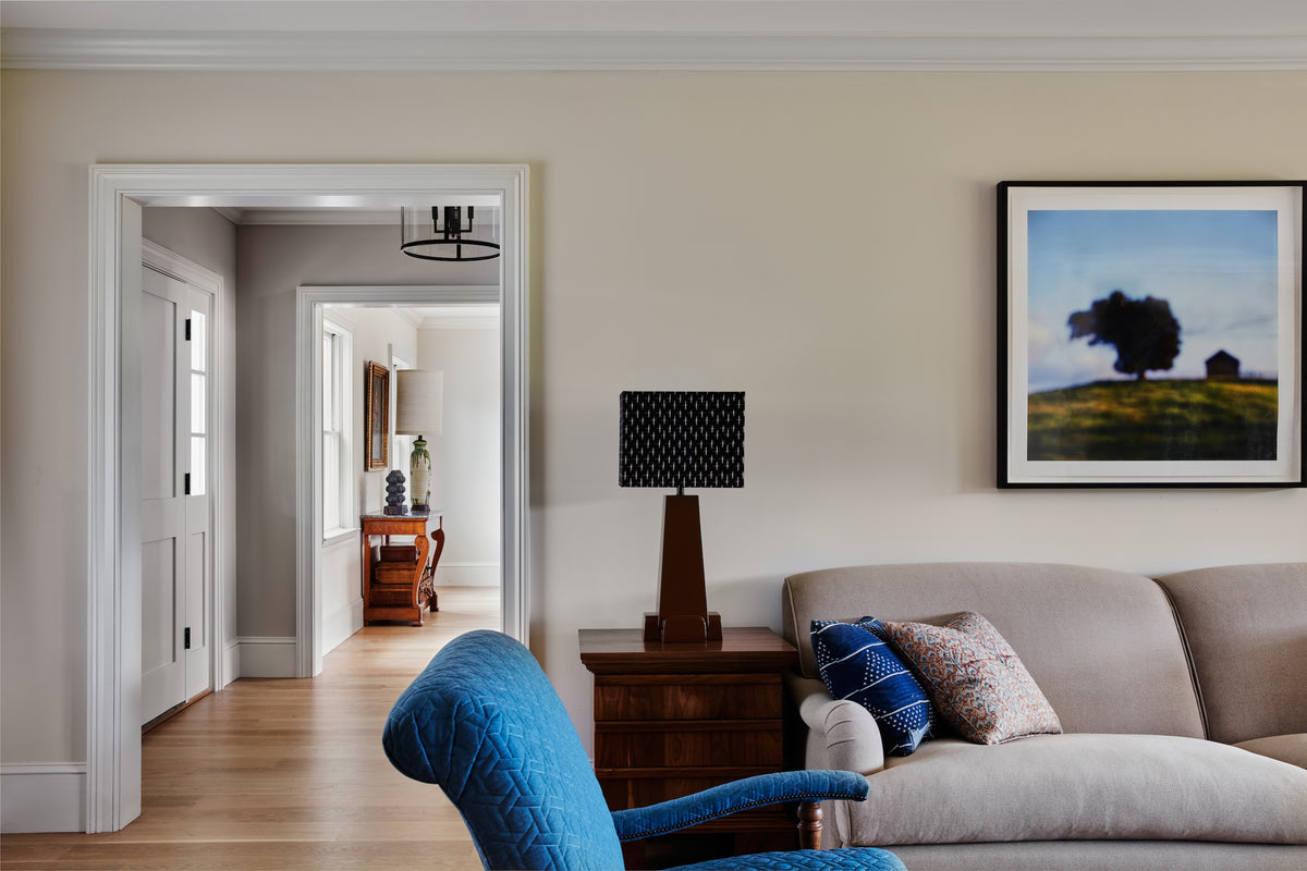 Framed landscape above a cream sofa with a view through to the hall, Martin & Brockett Hudson Valley
