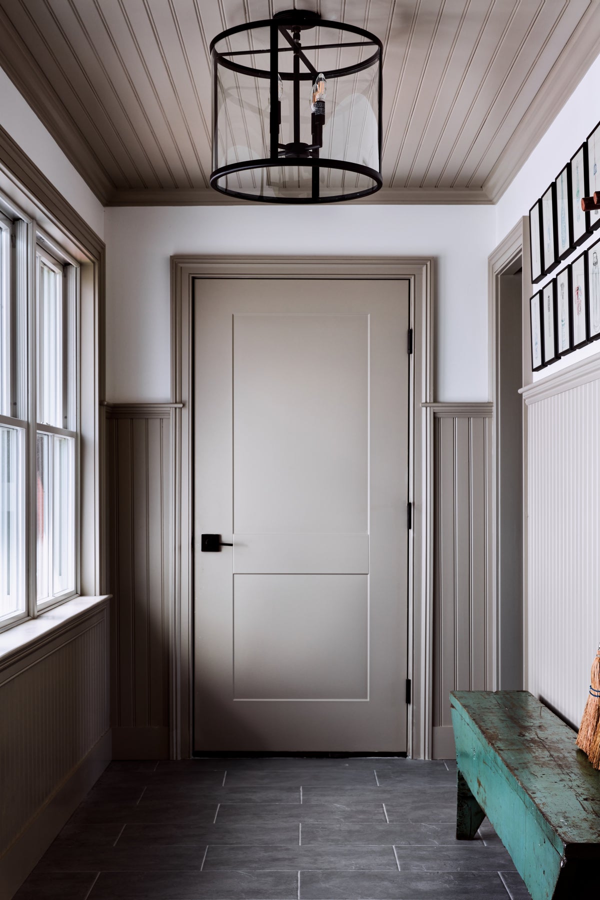 Lantern pendant above a green painted bench on slate tile, Martin & Brockett Hudson Valley mudroom