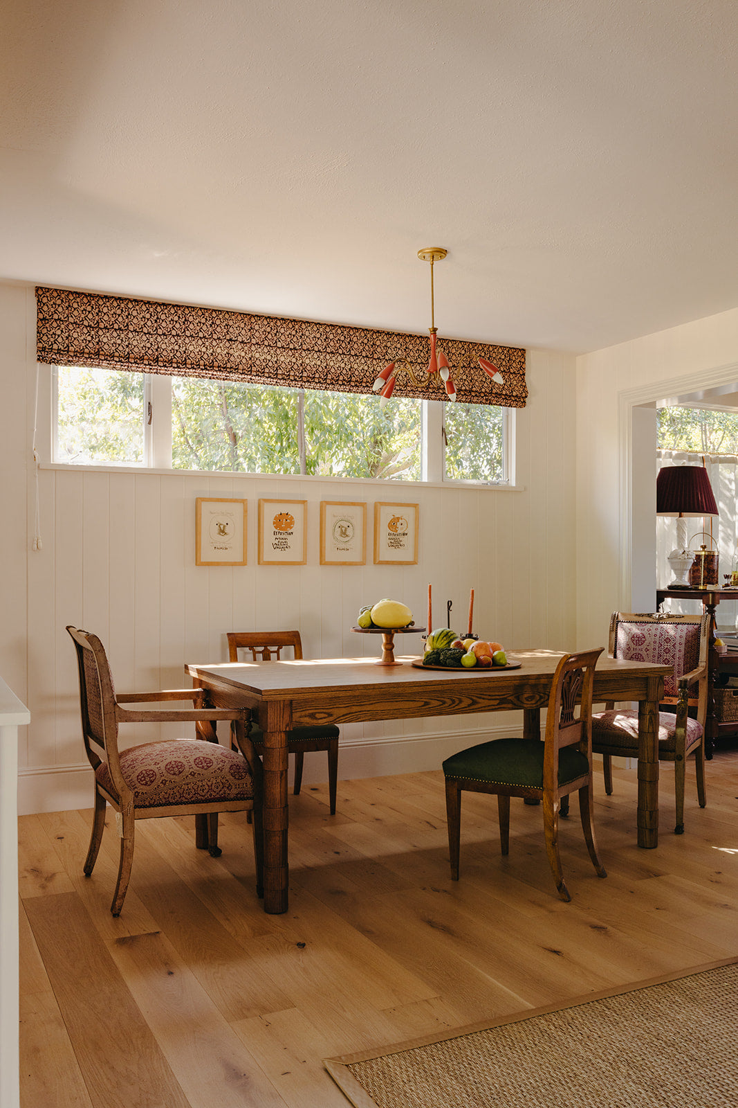 Natural woven roman shade filtering light across the Pasadena dining room by Martin & Brockett
