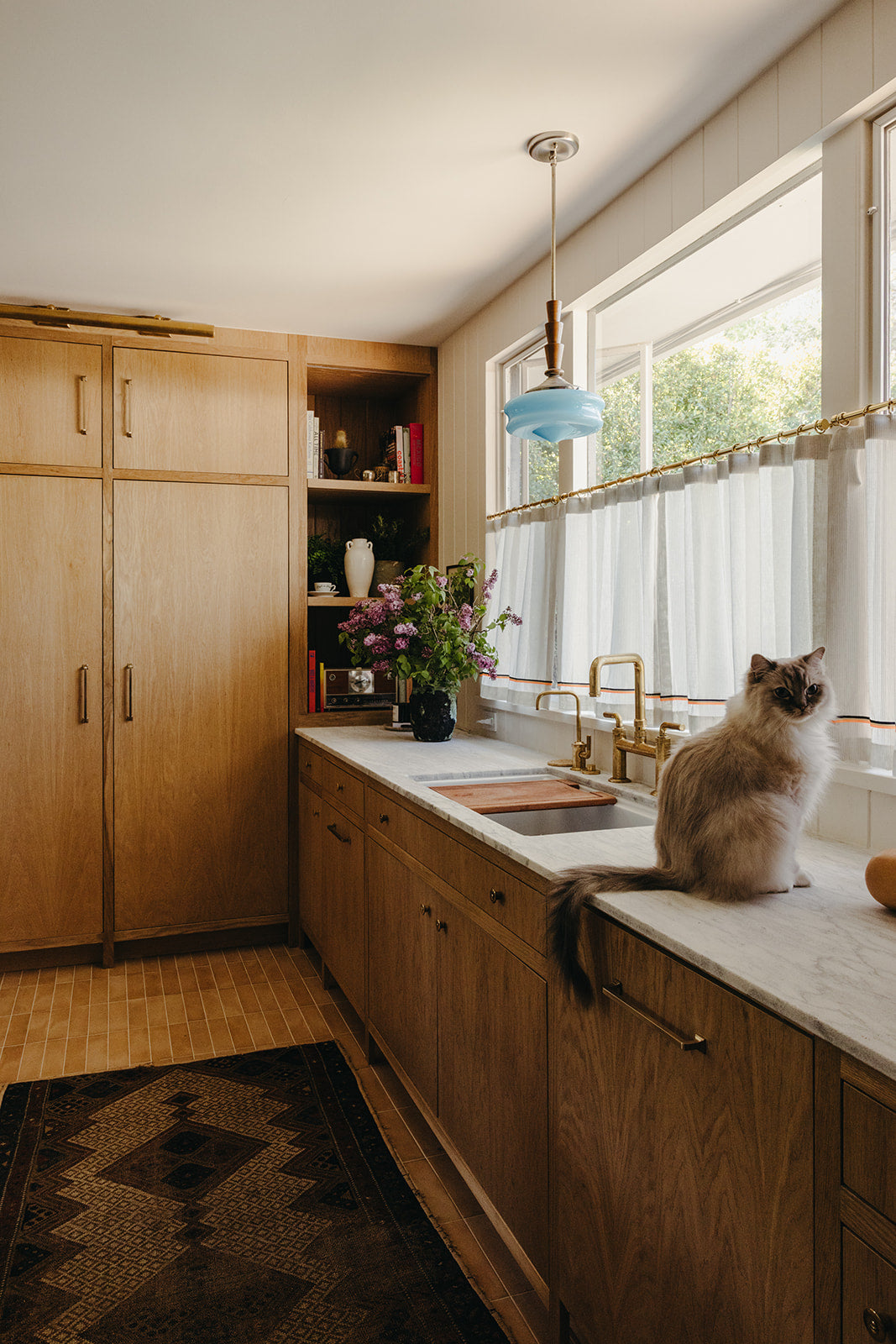 Farmhouse sink below a pendant light in the Martin & Brockett Pasadena kitchen
