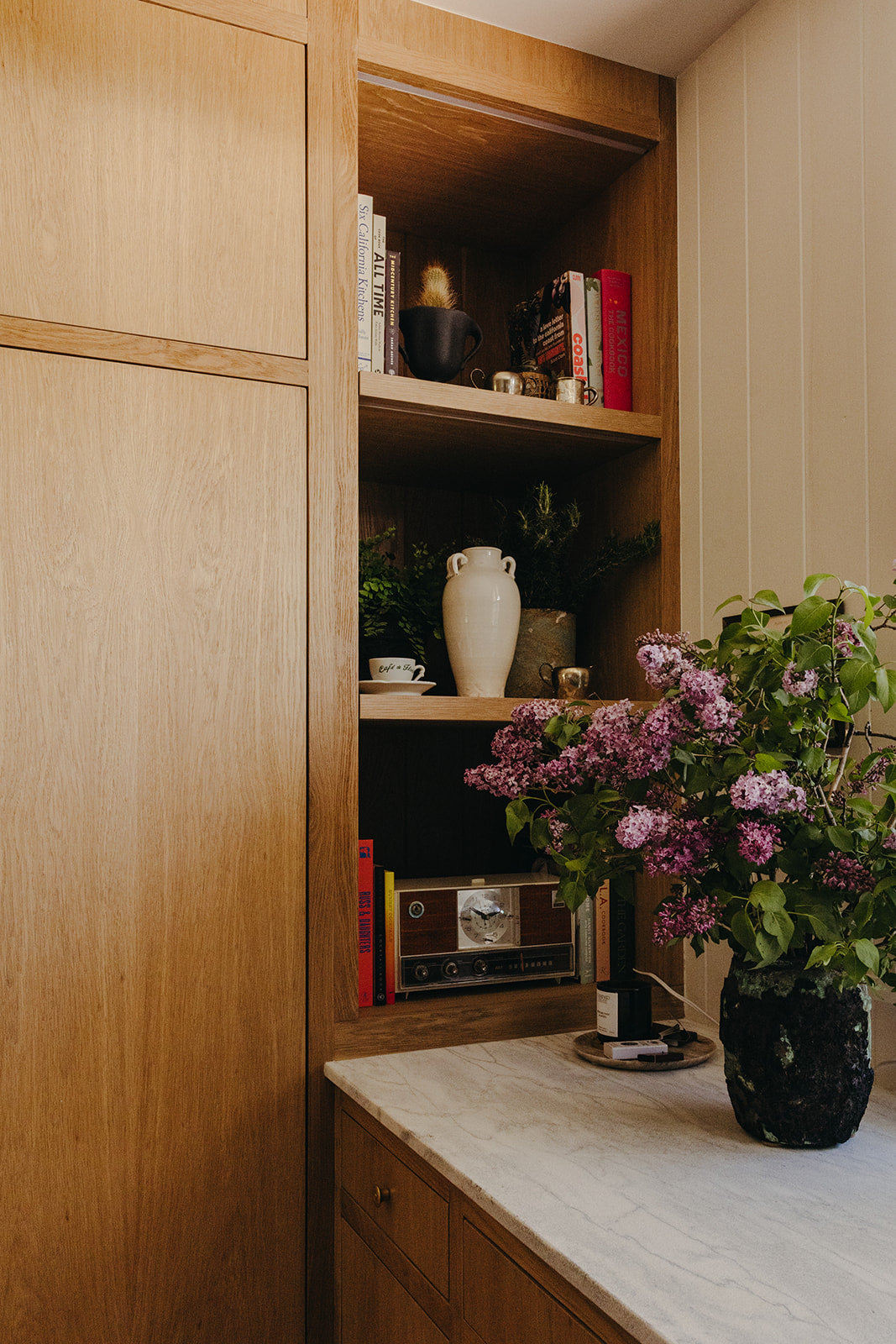 Open shelving above a marble counter with lilacs, Martin & Brockett Pasadena kitchen