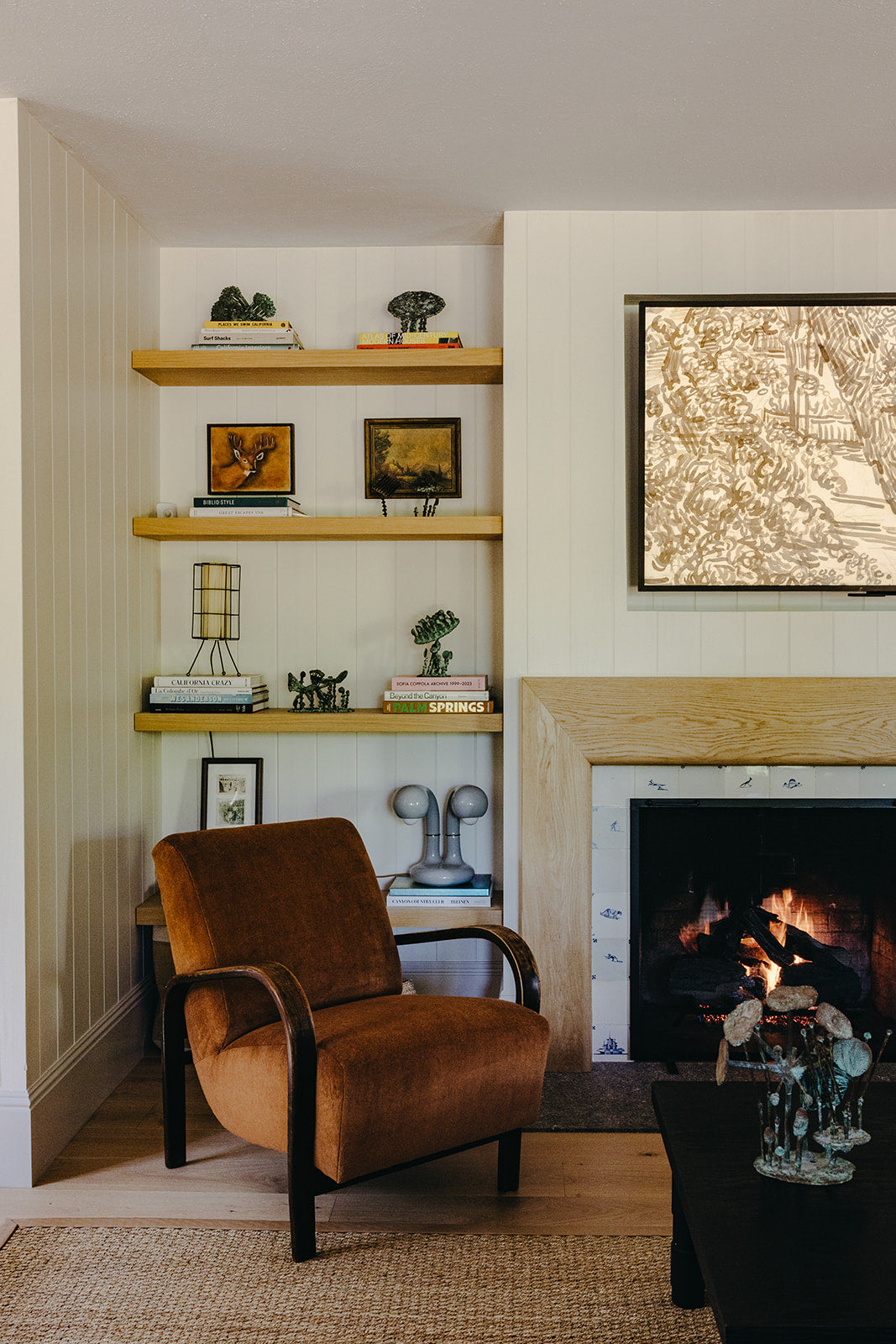 Rust leather lounge chair beside the fireplace in the Pasadena living room by Martin & Brockett