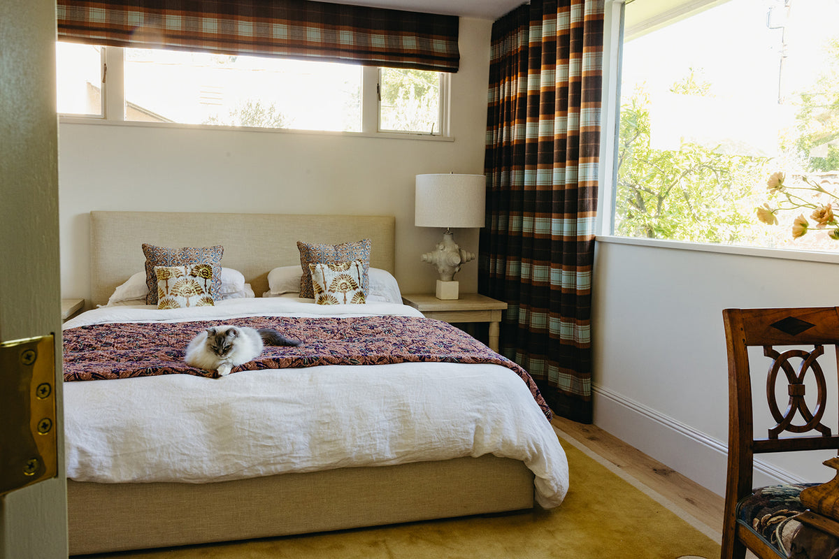 Plaid drapery and linen bedding in the primary bedroom of Martin & Brockett's Pasadena project