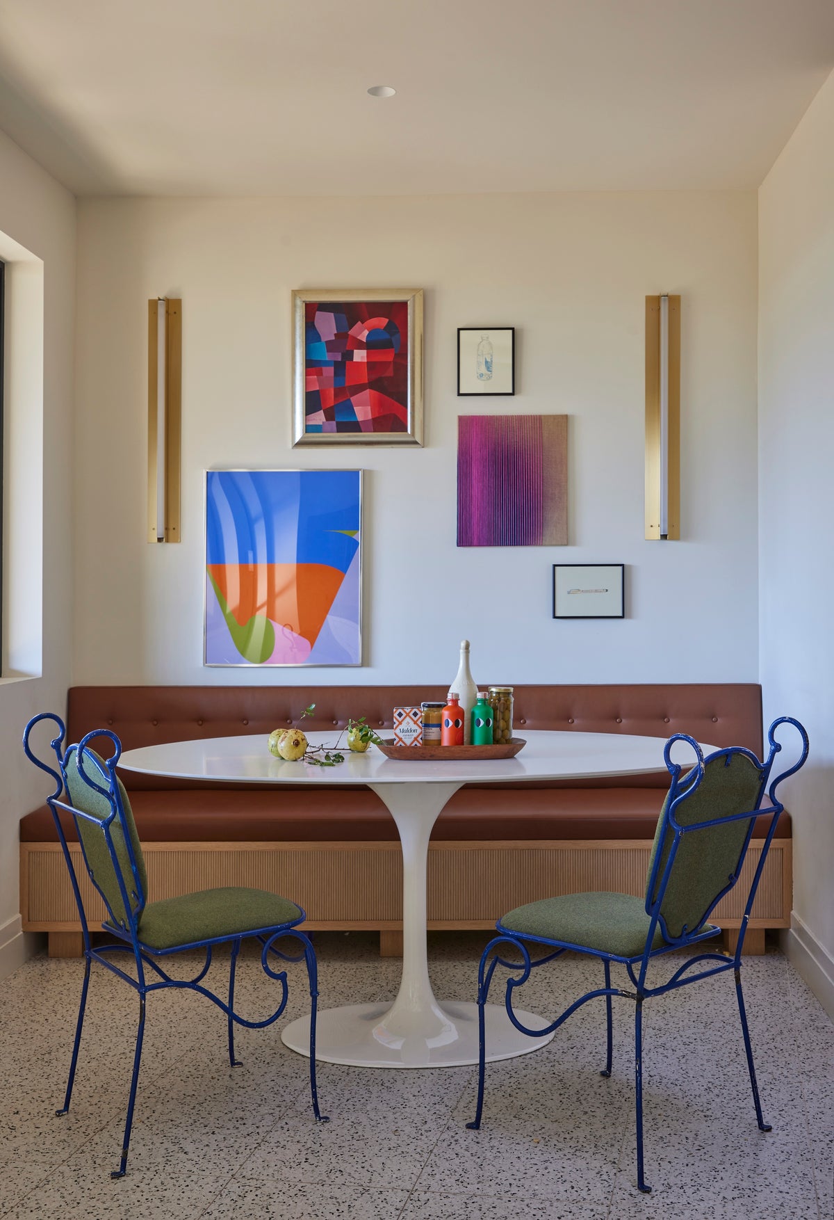 Banquette and tulip table below a gallery of abstract art, Martin & Brockett San Rafael breakfast nook