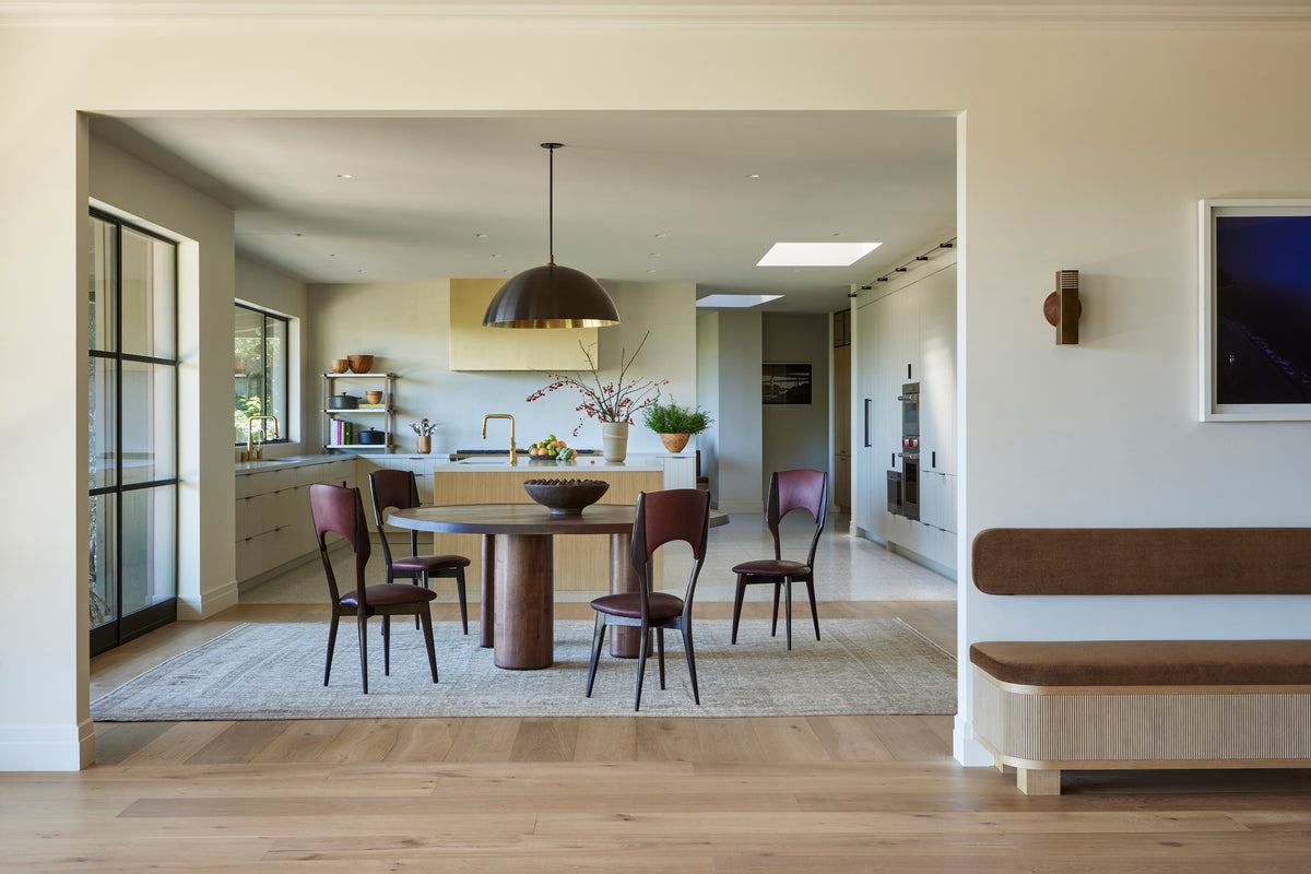 Round pedestal table and plum chairs under a brass dome pendant, Martin & Brockett San Rafael dining room