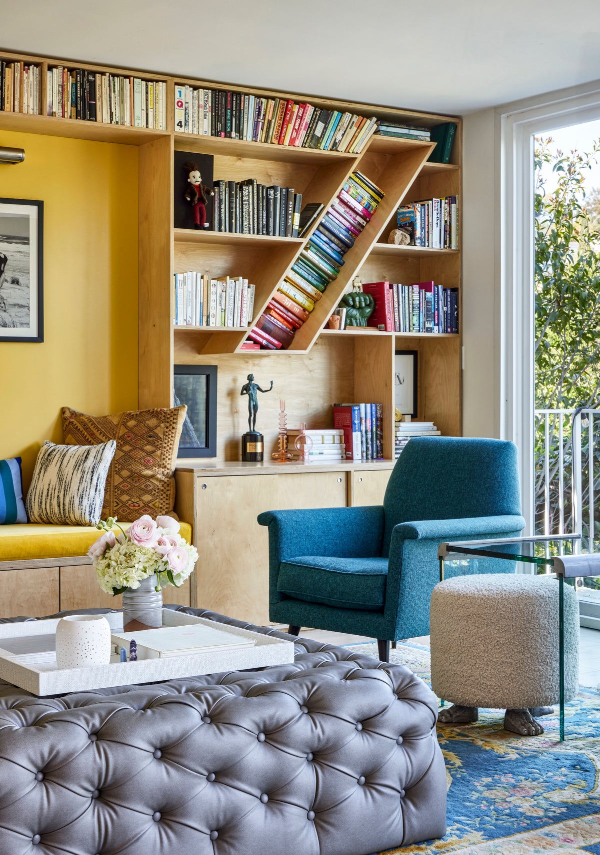 Library ladder against yellow-backed shelving with a teal armchair, Martin & Brockett Silverlake