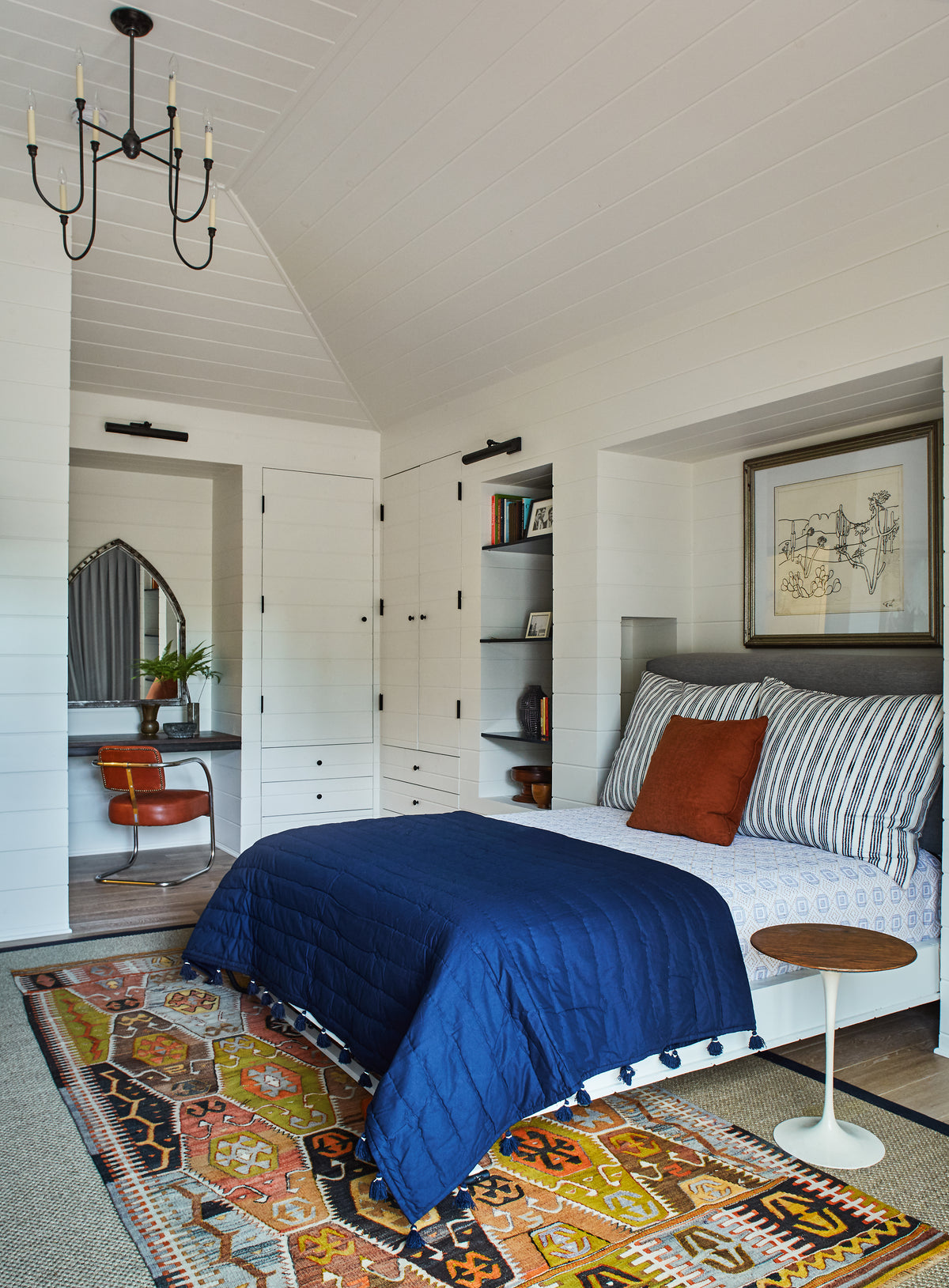 Vaulted shiplap ceiling above navy bedding and a kilim rug, Martin & Brockett Studio City bedroom