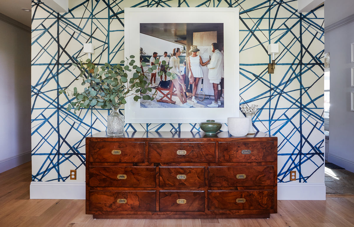 Blue trellis wallpaper behind an antique campaign chest in the entry, Martin & Brockett Studio City