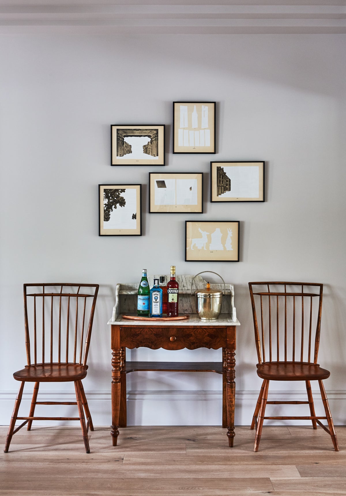 Antique side table and Windsor chairs below a gallery wall, Martin & Brockett Toluca Lake entry