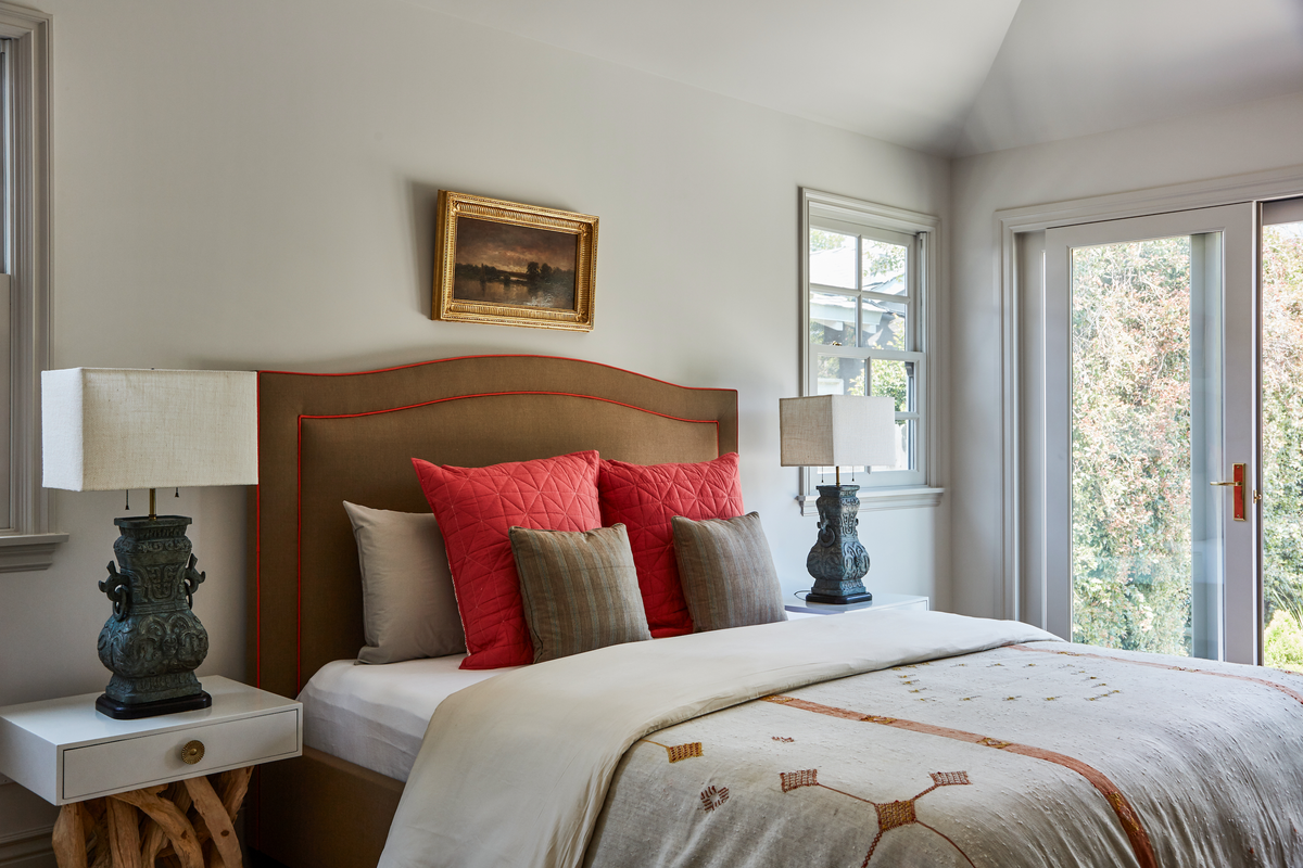 Gilt-framed landscape above an upholstered headboard and driftwood lamps, Martin & Brockett Toluca Lake
