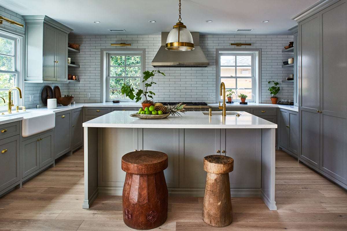 Marble island with carved wood stools below a brass pendant, Martin & Brockett Toluca Lake kitchen