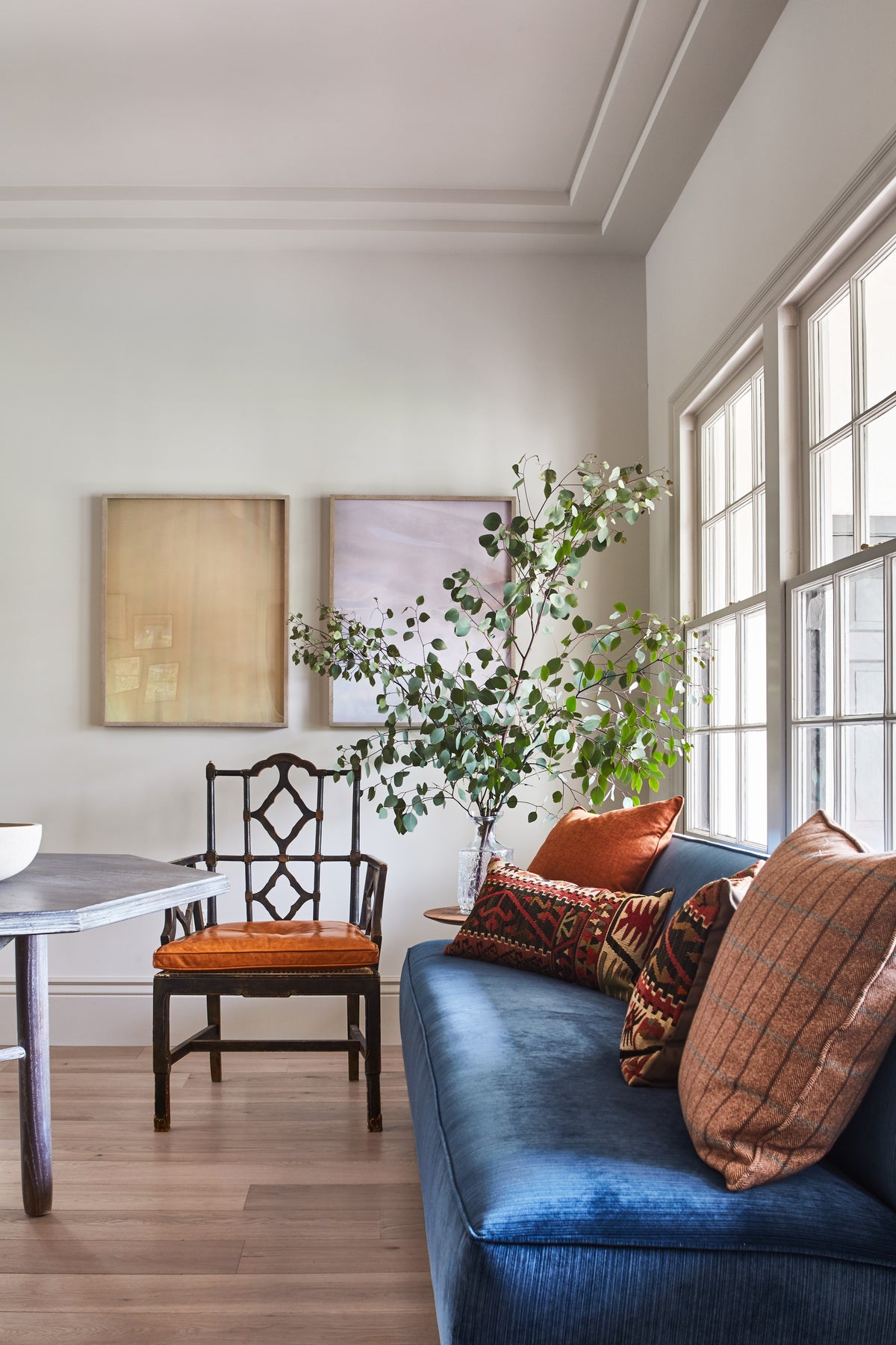 Blue velvet sofa with rust pillows against a wall of windows, Martin & Brockett Toluca Lake