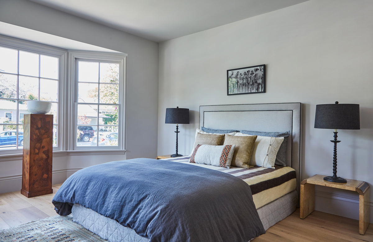 Upholstered bed between twin lamps beside a bay window, Martin & Brockett Toluca Lake primary bedroom